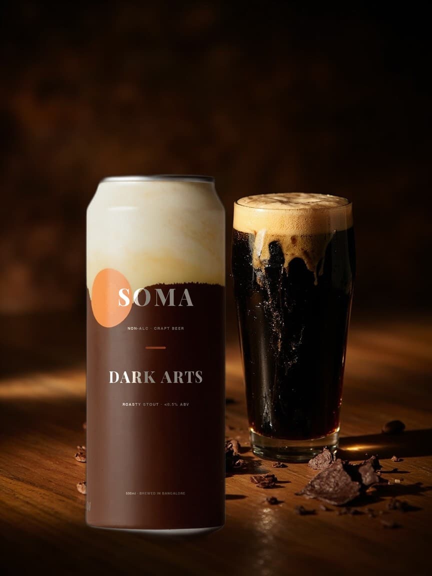 SOMA Stout can on a bar counter beside a pint of black stout with a tan head